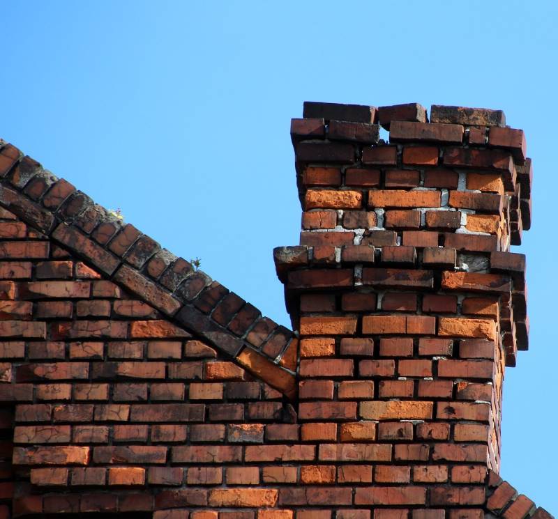 Signs Your Macomb Home Needs a Chimney Inspection Blog Article - Damaged chimney on an Macomb home showing cracks and missing mortar